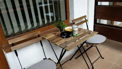 a wooden table and chair on a balcony at Pine Tree Apartment 2 - B7 in Bansko