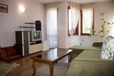 a living room with a tv and a coffee table at Guest House Ilinden in Bansko