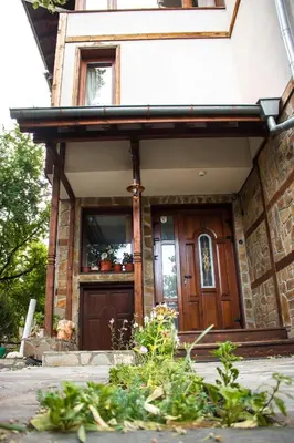 a house with a wooden door in front of it at Guest House Ilinden in Bansko