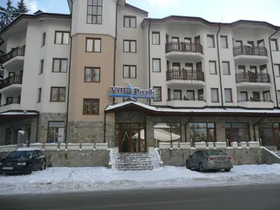 a large building with cars parked in front of it at HQ apartments Villa Park in Borovets