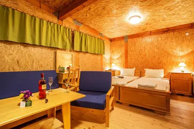 a bedroom with a bed and a table with a bottle of wine at Debeli Dab in Stara Kresna