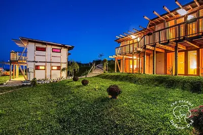 a house with a grass yard next to a building at Debeli Dab in Stara Kresna