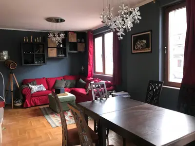 a living room with a table and a red couch at Gondola Flat Number 5 in Bansko