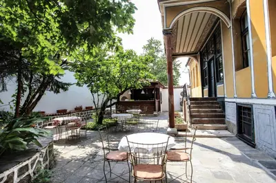 a patio with chairs and tables and a building at Guest House Old Plovdiv in Plovdiv
