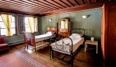 a bedroom with two beds and a chair at Guest House Old Plovdiv in Plovdiv