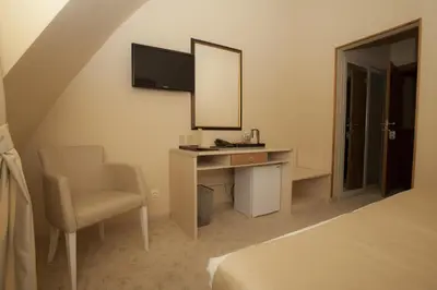 a bedroom with a desk and a mirror and a chair at Family Hotel Saint George in Sofia