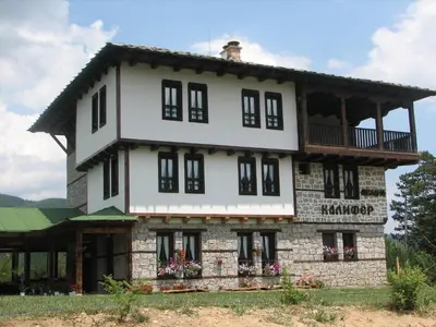 a house with a balcony on top of it at Family Hotel Kalifer in Kalofer