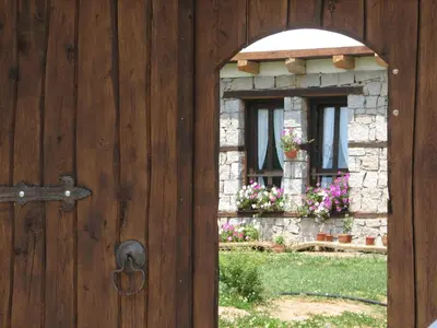 a wooden door with a window with flowers on it at Family Hotel Kalifer in Kalofer