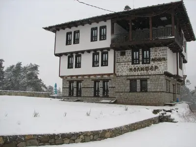 a large building with snow on top of it at Family Hotel Kalifer in Kalofer