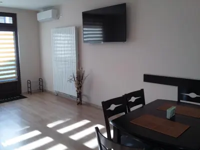 a dining room with a table and a television on the wall at Guest House Ideal in Sapareva Banya