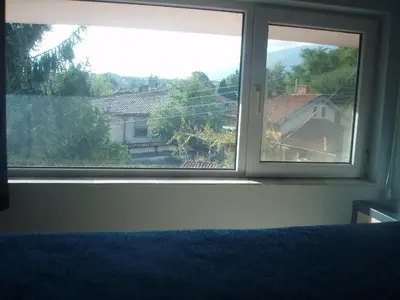 a bedroom window with a view of a house at Mania Guest House in Kalofer