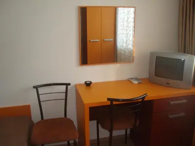 a room with a desk with a television and two chairs at Mania Guest House in Kalofer