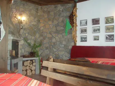 a bedroom with a stone wall with a bed and a fireplace at Mania Guest House in Kalofer