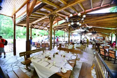 a restaurant with tables and chairs and people in the background at Family Hotel Gorski Kut in Rilski Manastir