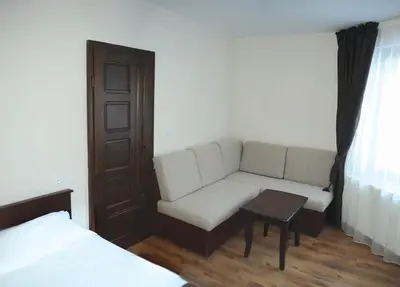 a living room with a couch and a table at СТАИ ЗА ГОСТИ в КЪЩА КАМЕЛИЯ in Pamporovo