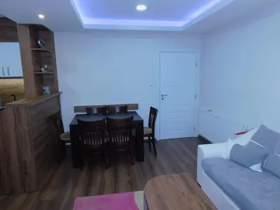 a living room with a couch and a table and chairs at Vihren Boutique Apartment in Bansko