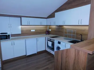 a kitchen with white cabinets and a stove top oven at Vihren Boutique Apartment in Bansko