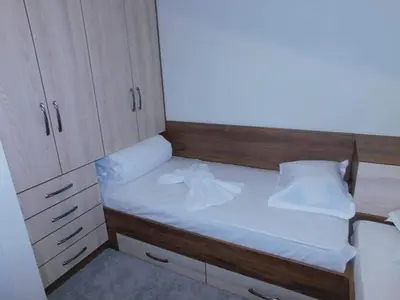 a small bed in a small room with cabinets at Vihren Boutique Apartment in Bansko