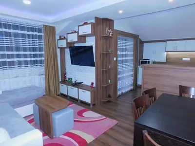 a living room with a couch and a dining room at Vihren Boutique Apartment in Bansko