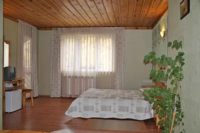 a bedroom with a bed and a large window at Family Hotel Shoky in Chepelare