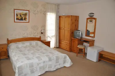 a bedroom with a bed and a television in it at Family Hotel Shoky in Chepelare