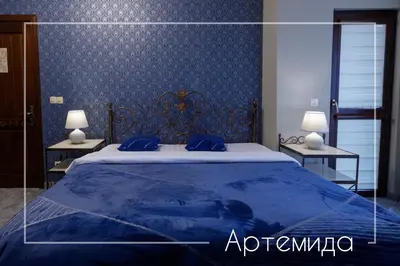 a bedroom with a blue bed with two tables at Boutique & Spa Hotel Heaven in Velingrad