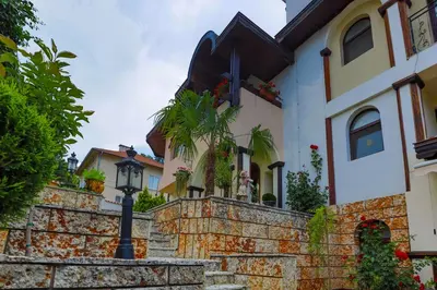a house with a stone wall and a street light at Boutique & Spa Hotel Heaven in Velingrad