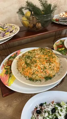 a table with plates of food and a pizza at Hotel Mursalitsa by HMG - Half board in Pamporovo