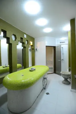a bathroom with a green tub and a sink at Hotel Mursalitsa by HMG - Half board in Pamporovo