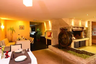 a living room with a large stone fireplace at Hotel Mursalitsa by HMG - Half board in Pamporovo