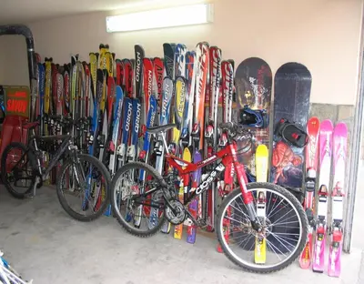 a bunch of snowboards and bicycles are lined up against a wall at Family Hotel Savov in Chepelare