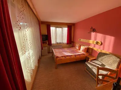 a small room with a couch and a window at Family Hotel Savov in Chepelare