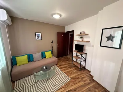 a living room with a couch and a television at Ramada 2 - Apartment in Bansko