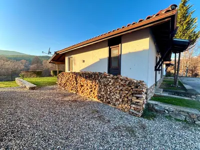a building with a pile of fire wood next to it at Villa Bachevo Horizon in Bachevo