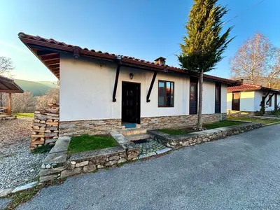 a small white house with a black door at Villa Bachevo Horizon in Bachevo