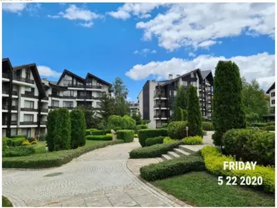 a courtyard with some bushes and some buildings at Studio L006 in Aspen Golf in Bansko