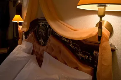a close up of a bed with a lamp at Hotel Chinar in Hisarya