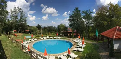 a pool with chairs and umbrellas next to a resort at Villa Mark in Kraevo