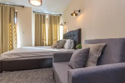 a bedroom with a bed and a couch at ★ Stylish & Cozy Studios in Valentina Heights Boutique Hotel ★ in Bansko
