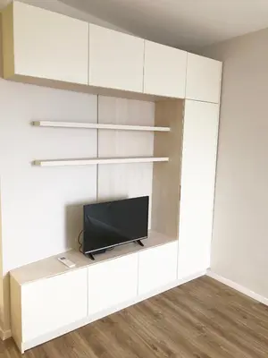a living room with a tv on a white wall at Turquoise and Magenta Apartment in Sofia