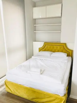 a bed with white sheets and a yellow headboard at Turquoise and Magenta Apartment in Sofia