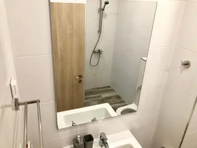 a bathroom with a mirror and a sink and a shower at Turquoise and Magenta Apartment in Sofia