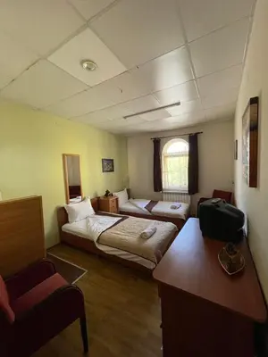 a room with two beds and a desk in it at Rooms Sonata in Kyustendil