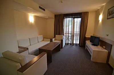 a hotel room with a couch and a television at Spa Hotel Kleptuza in Velingrad