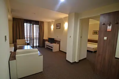 a hotel room with a couch and a living room at Spa Hotel Kleptuza in Velingrad