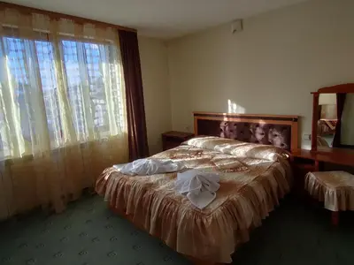 a bedroom with a bed and a desk and a window at Guest Rooms Grachenovi in Bansko