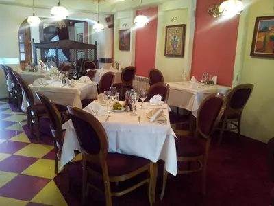 a dining room with tables and chairs with white table cloth at Hotel Kardinal in Blagoevgrad