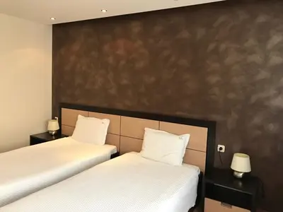 two beds sitting next to each other in a room at Hotel Kardinal in Blagoevgrad