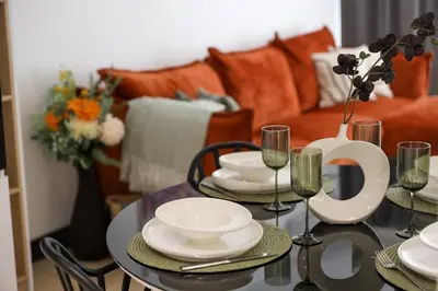 a dining room table with plates and wine glasses at Hotel Kardinal in Blagoevgrad