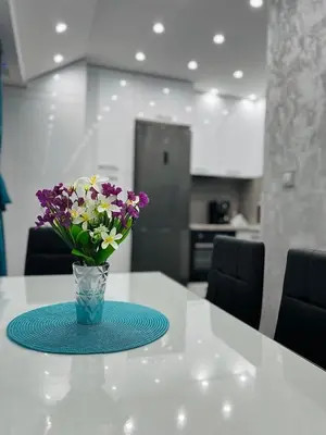 a vase with purple and white flowers on a table at City Apartments - a brand new luxury & comfy. in Asenovgrad
